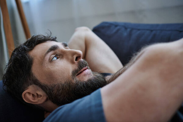 депрессивный бородатый человек в повседневной одежде лежал на диване во время поломки, психического здоровья осведомленности