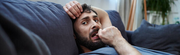 depressed hopeless man in home wear lying on sofa during mental breakdown, psychotherapy, banner