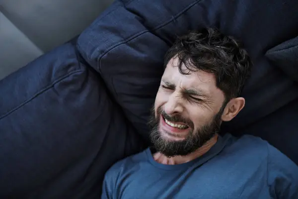 stock image anxious man with beard in casual clothes suffering during breakdown, mental health awareness