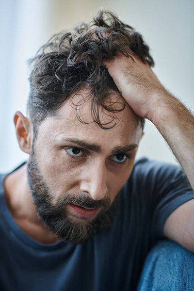 sick depressed man with beard with hand on his face during breakdown, mental health awareness