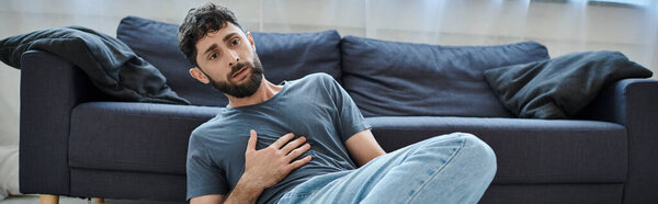 anxious traumatized man in home wear having severe panic attack, mental health awareness, banner