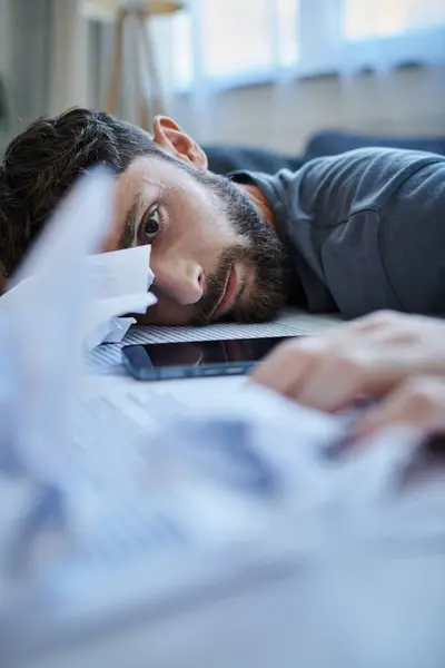 stock image suffering frustrated man with beard with head on table during breakdown, mental health awareness