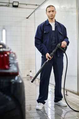 Siyah arabayı yıkamadan önce mavi üniformalı yakışıklı profesyonel bir askerin elinde hortum vardı.