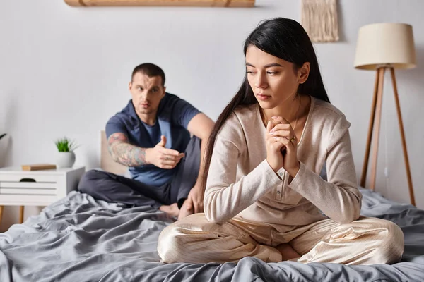 Young Man Talking Upset Asian Woman While Sitting Bed Home — Stock Photo, Image