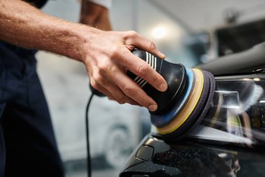 Çalışkan profesyonellerin özel makineli üniforma parlatma arabalarıyla çalışmalarının kırpılmış görüntüsü