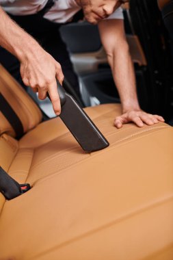 Otoparkta elektrikli süpürge kullanan kendini işine adamış bir işçinin görüntüsü.