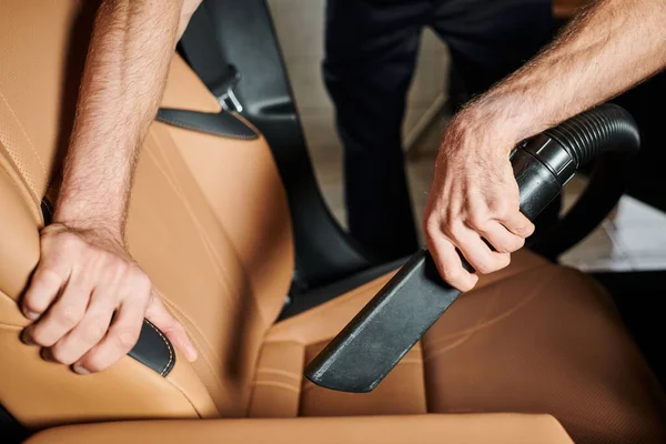 stock image cropped view of dedicated hard working professional serviceman using manual vacuum cleaner in car