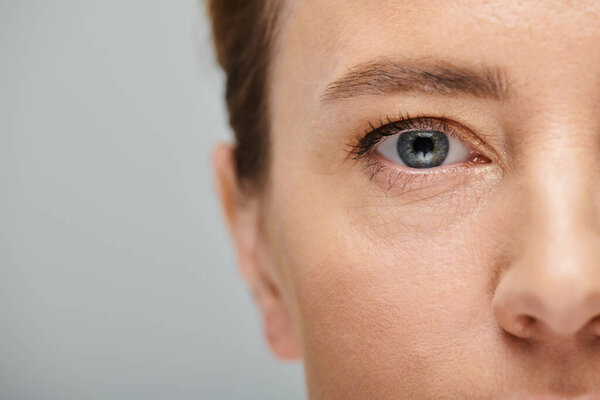 close up of appealing woman with blonde hair looking at camera with contact lense on her eye