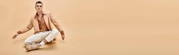 Красивый Мужчина Бежевой Куртке Очках Сидит Позе Лотоса Персиковом Бежевом — стоковое фото