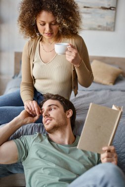 Casual conversation over morning coffee, curly young woman and brunette man enjoy time together clipart