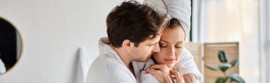 Portrait of happy man and woman in love in bathrobes in the bathroom, hugging each other, banner clipart