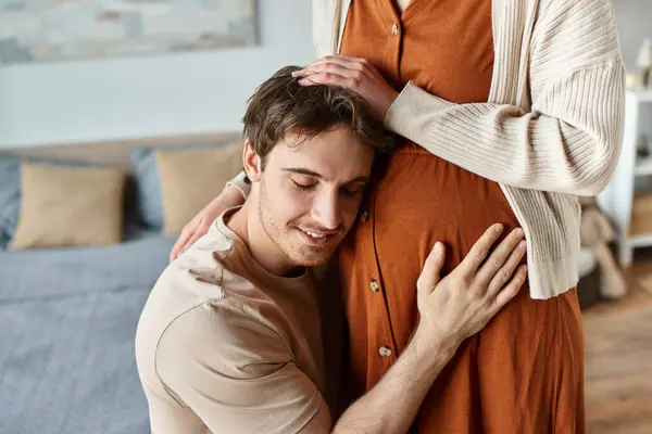 妊娠中の妻の腹で赤ちゃんを聞いている夫のクロップされたイメージ 両親を抱擁 — ストック写真