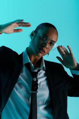 A young black woman in a suit and tie raises her hands in an elegant gesture. clipart