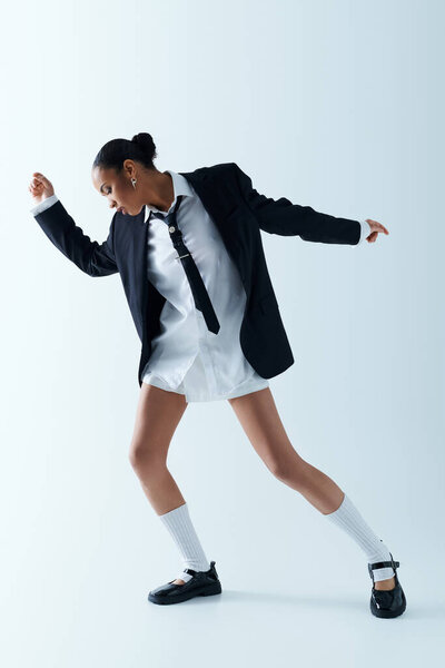 A young African American woman exudes elegance and sophistication in a studio setting