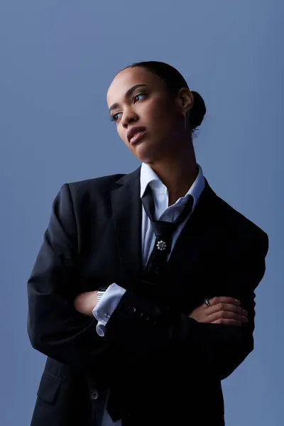 A young African American woman confidently posing in a suit and tie for a portrait