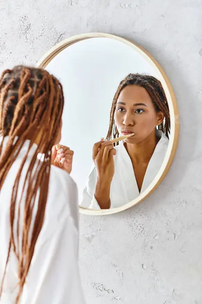 Afroamerikansk Kvinna Med Afro Flätor Badrock Borsta Tänderna Framför Spegel — Stockfoto