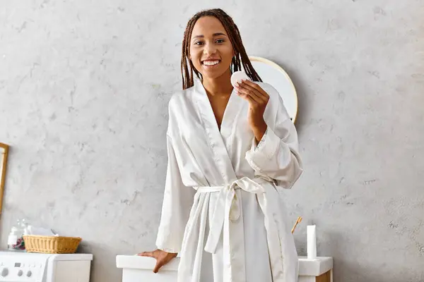 白いローブのアフリカ系アメリカ人女性は 彼女の現代的なバスルームに優雅に立って 美しさと静けさを放射します — ストック写真