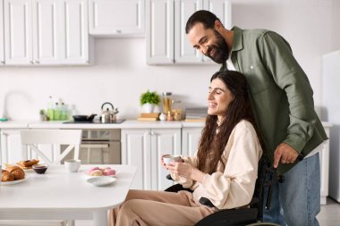 positive loving man spending time at breakfast with his disabled beautiful wife in wheelchair clipart