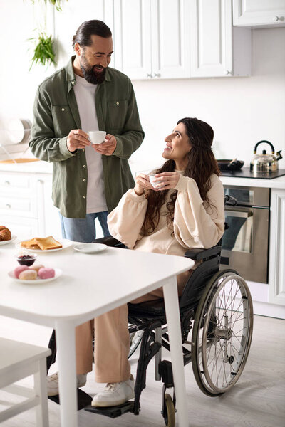 cheerful beautiful disable woman in wheelchair enjoying coffee with her husband during breakfast