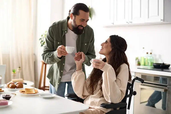 朝食中に夫とコーヒーを楽しんでいる車椅子の陽気で美しい無効な女性 — ストック写真