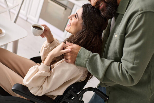 cropped view of cheerful disabled woman in wheelchair drinking coffee with her husband at breakfast