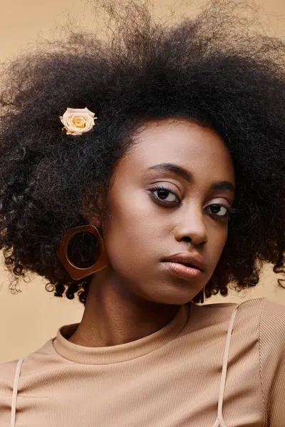 性感的年轻非洲姑娘 长着一头卷曲的玫瑰 背景是米黄色的 有桃红色的绒毛 — 图库照片