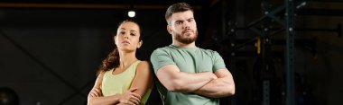 Bir erkek antrenör, spor salonunda bir kadına savunma teknikleri öğretir..