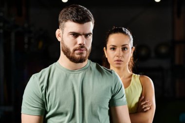 Erkek antrenör, spor salonunda bir kadına kendini savunma teknikleri gösterir..