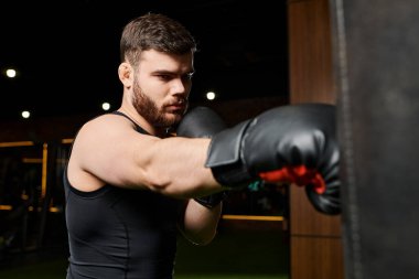 A handsome man with a beard wearing boxing gloves, throwing punches at a punching bag in a gym. clipart