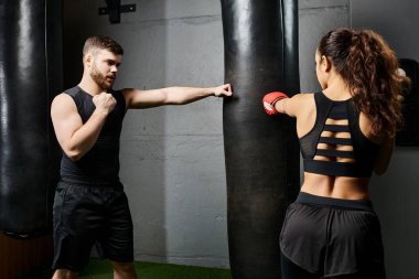 A male trainer guides a brunette sportswoman in active wear as they spar in a boxing ring during a rigorous training session. clipart
