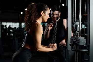 A personal trainer guides a brunette sportswoman in a workout at the gym, both driven and focused on achieving fitness goals. clipart