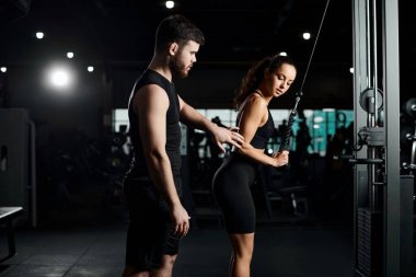 personal trainer works with a brunette sportswoman in the gym, demonstrating exercises and providing guidance. clipart