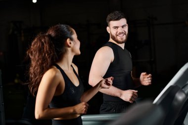 Spor salonunda esmer bir sporcunun yanında duran özel antrenör antrenman için hazırdır..