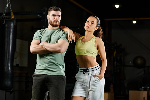 A male trainer shows a woman proper self-defense techniques in a gym setting.