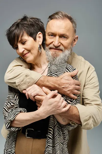 Orta yaşlı şık giyinmiş bir çift stüdyo ortamında birbirlerine nazikçe sarılıyorlar..