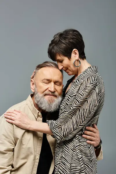 Orta yaşlı bir çift, zarif giyinmiş, zarif bir şekilde birbirlerine sarılıyorlar..