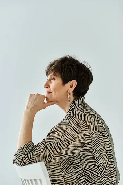 Kobieta Średnim Wieku Krótkimi Włosami Siedzi Krześle Kładąc Podbródek Dłoni — Zdjęcie stockowe