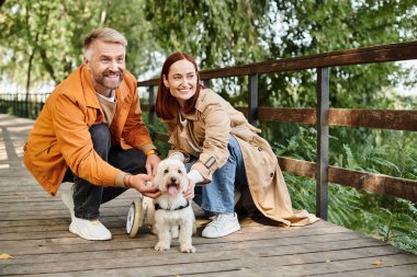 Yetişkin çiftler köprüde gezerken köpek beslerler..
