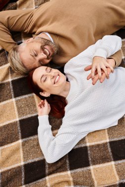 Bir adam ve bir kadın parkta bir battaniyenin üzerinde huzur içinde yatıyorlardı..