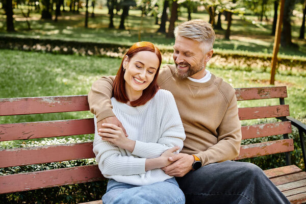 A man and a woman enjoying a peaceful moment on a park bench.