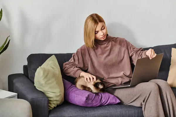 一个安静的女人 留着短发 躺在沙发上休息 腿上抱着一只安静的猫 — 图库照片