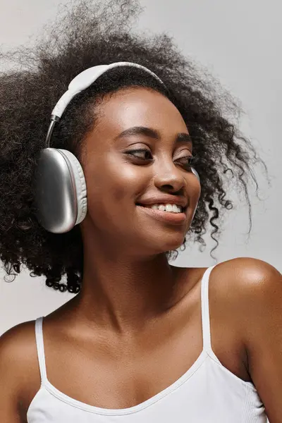 Una Joven Afroamericana Con Pelo Rizado Sonríe Mientras Usa Auriculares — Foto de Stock