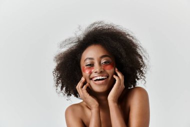 A young African American woman with curly hair in a studio setting, showcasing beauty and skin care clipart