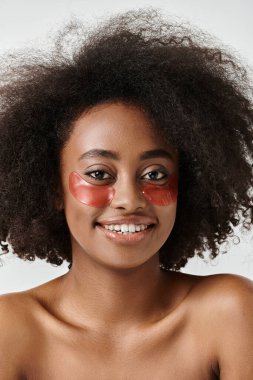 A stunning African American woman with curly hair wearing a bold red eye patch looks fierce and confident. clipart