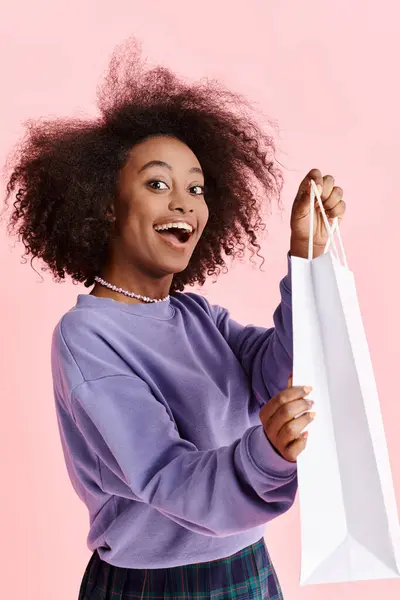 ショッピングバッグを持ち 喜んで笑っているカーリーヘアの美しいアフリカ系アメリカ人女性 — ストック写真