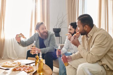 Farklı etnik kökenlere sahip üç neşeli, yakışıklı adam günlük kıyafetlerle bir masada gülüp pizza yiyorlar..