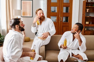 Three diverse, cheerful men in bathrobes relax on top of a couch and enjoy a great time together. clipart