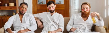 Three diverse, cheerful men in bathrobes sitting happily together on top of a couch. clipart