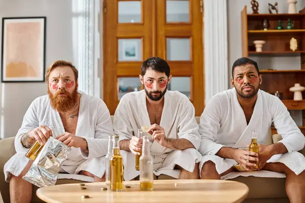 Three Pensive Diverse Men Bathrobes Sit Atop Couch Sharing Good — Stock Photo, Image