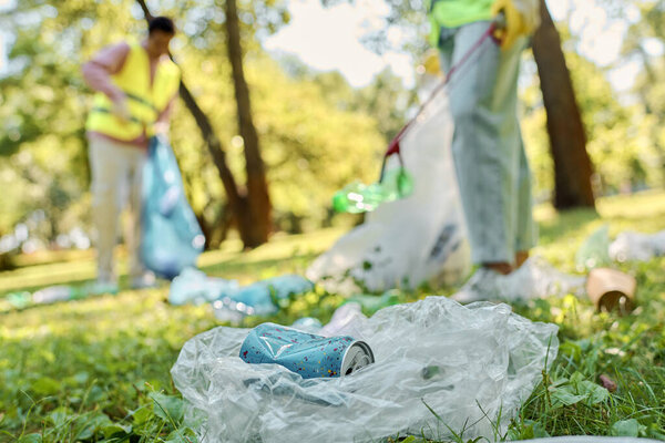A socially active, diverse loving couple in safety vests and gloves cleaning up trash in a park, promoting environmental protection and community involvement.